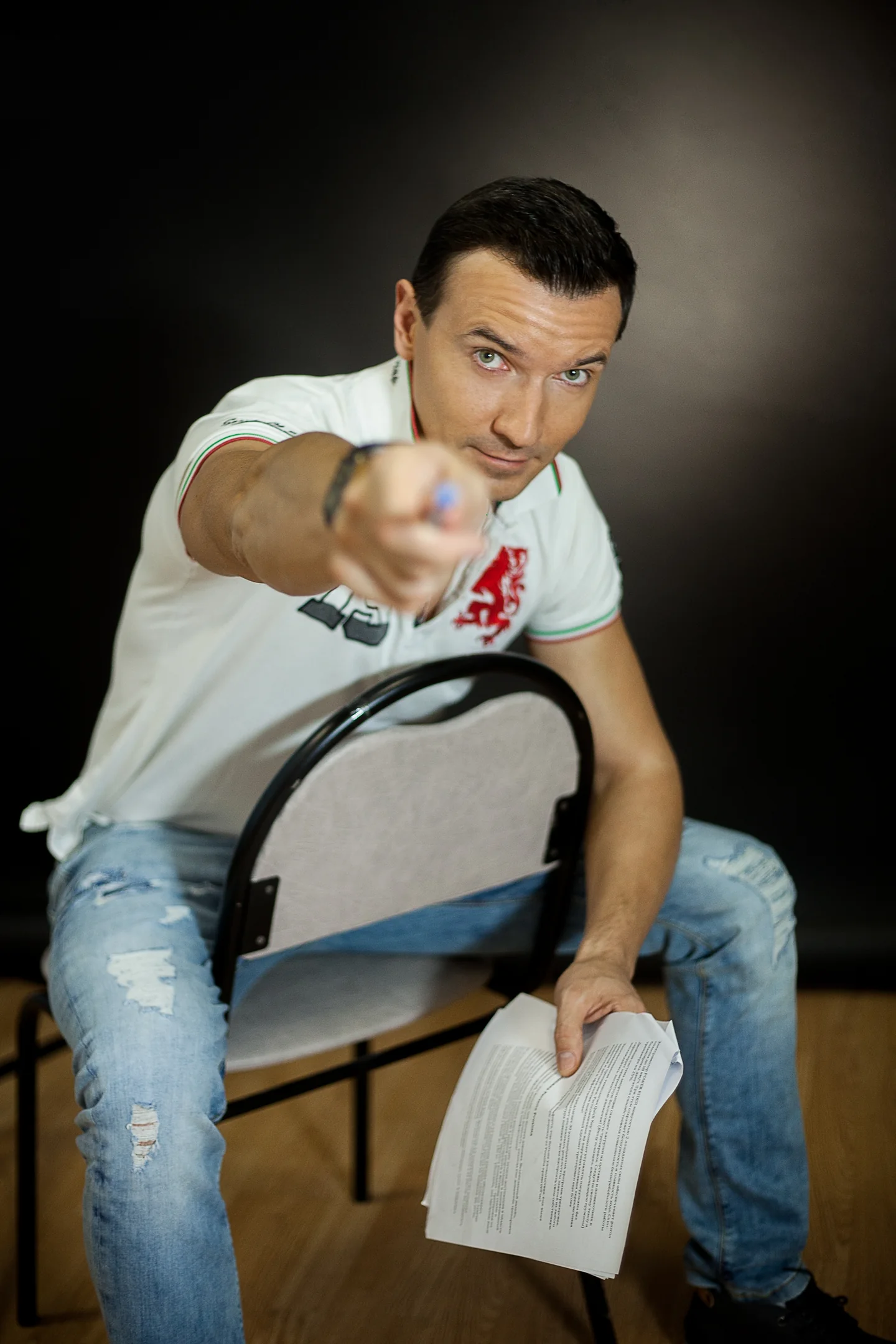 Roman looks into the camera and points a pencil towards the viewer